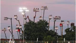 Kibice wynajęli dźwigi, aby wziąć udział w sportowym wydarzeniu.