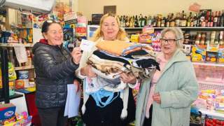 Seniorzy szyją torby wielorazowego użytku.