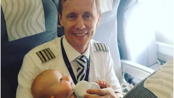 Fiński pilot Tom Nystrom uwieczniony przez koleżankę z pracy podczas karmienia dziecka pasażerki.